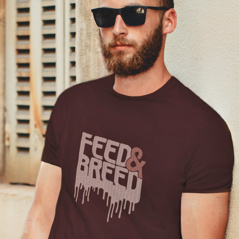 PRODUCT IMAGE: Feed & Breed T-shirt | Raunchy Tees for Horny Gay Guys | Model wears Oxblood shirt with typographic design