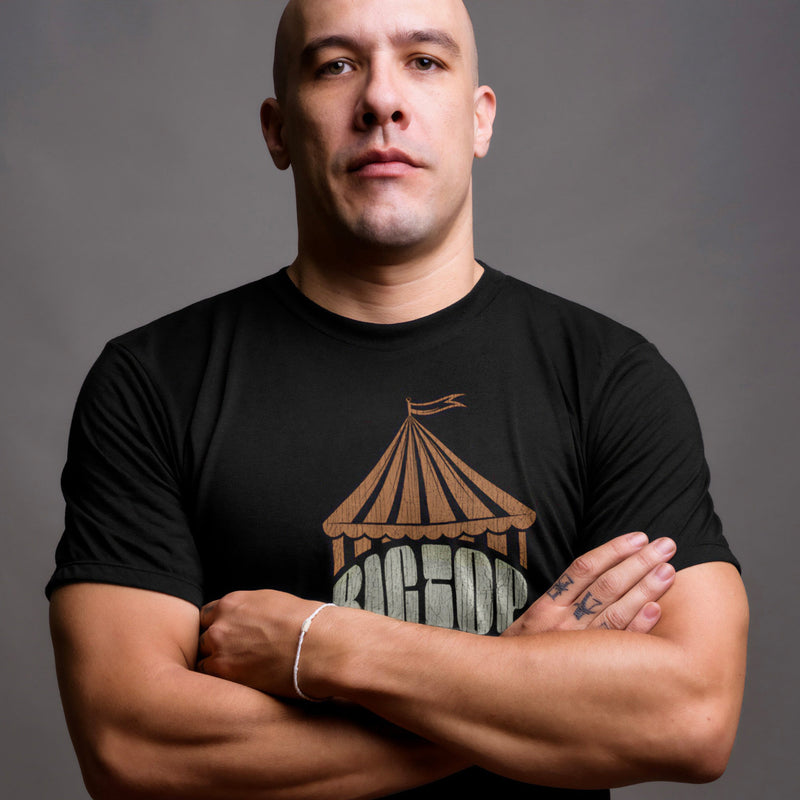PRODUCT IMAGE: Big Top T-shirt | Raunchy Tees for Gay Alpha Males, Queer Top Guys | Model wears Black shirt, the graphic formed with bold typography covered with an abstractly shaped circus "big top" 