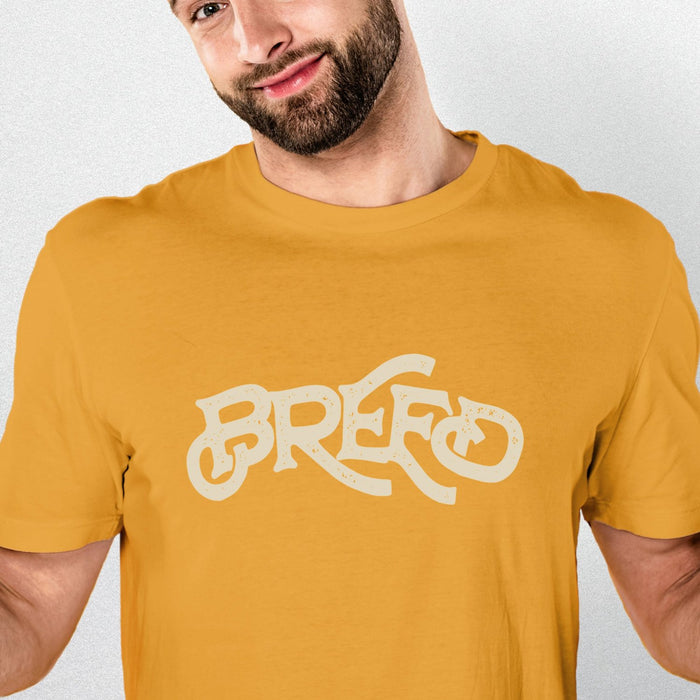 PRODUCT IMAGE: Breed T-shirt | Raunchy Tees for Horny Gay Guys Who Bareback, Love Cum | Model wears typographic design on Mustard shirt