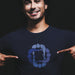Model wears navy cotton t-shirt with subtle circle graphic of seated male figures holding hands (Circle Jerks), viewed from above; gay-themed design for bators and group play