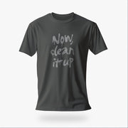 Product image of the asphalt color t-shirt with "Now, clean it up" printed on the chest; the  milky white letterforms drip, lending to an appropriate interpretation