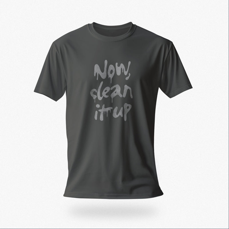 Product image of the asphalt color t-shirt with "Now, clean it up" printed on the chest; the  milky white letterforms drip, lending to an appropriate interpretation