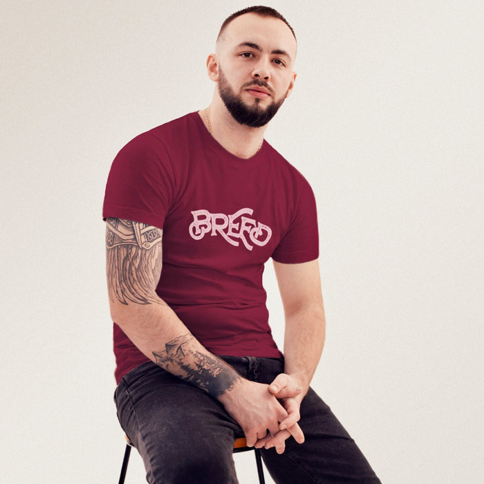 PRODUCT IMAGE: Breed T-shirt | Raunchy Tees for Horny Gay Guys Who Bareback, Love Cum | Model wears typographic design on Maroon shirt