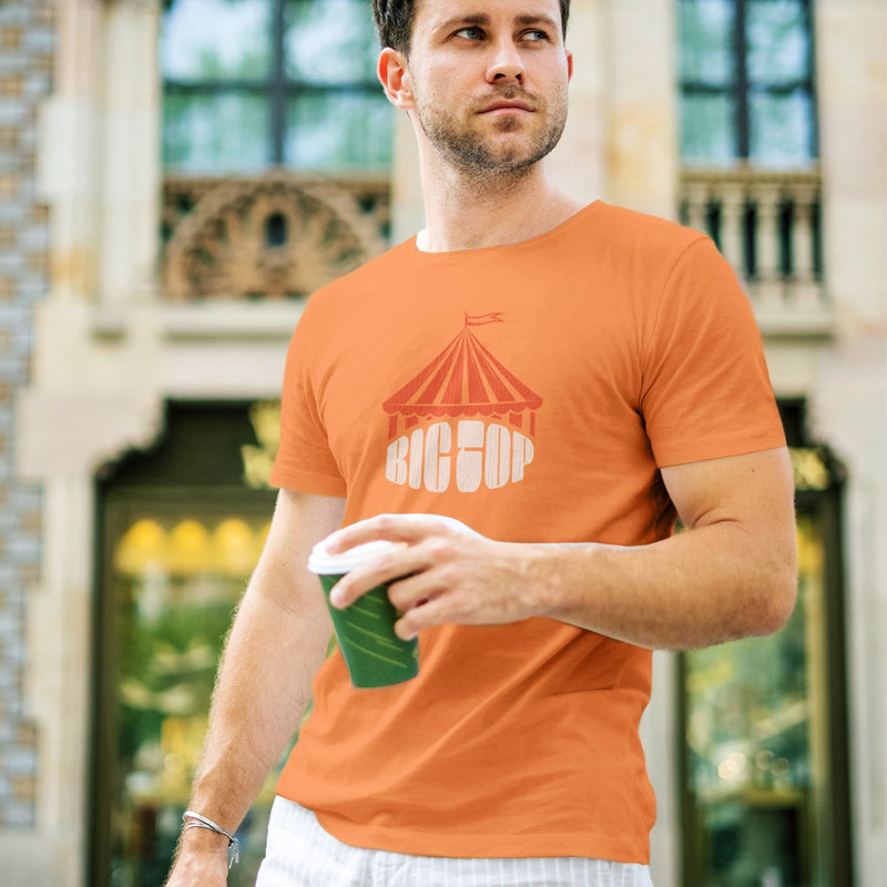 PRODUCT IMAGE: Big Top T-shirt | Raunchy Tees for Gay Alpha Males, Queer Top Guys | Model wears Orange shirt, the graphic formed with bold typography covered with an abstractly shaped circus "big top" 