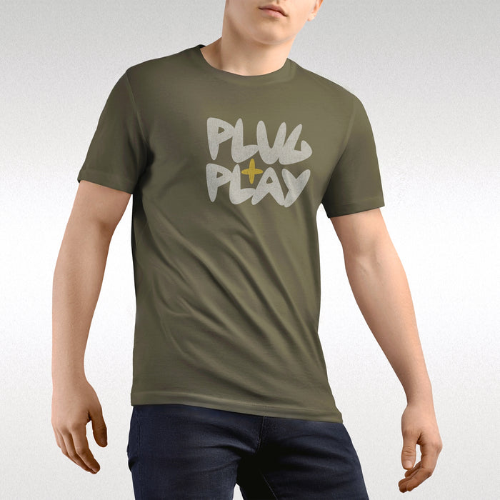 PRODUCT IMAGE: Plug + Play T-shirt | Funny, Dirty, Raunchy T-shirts for Horny Gay Guys who Play with Penis | Model wears Army1 shirt (G-rated version) | A typographic design uses the negative space of the letter a in the shape of a cock