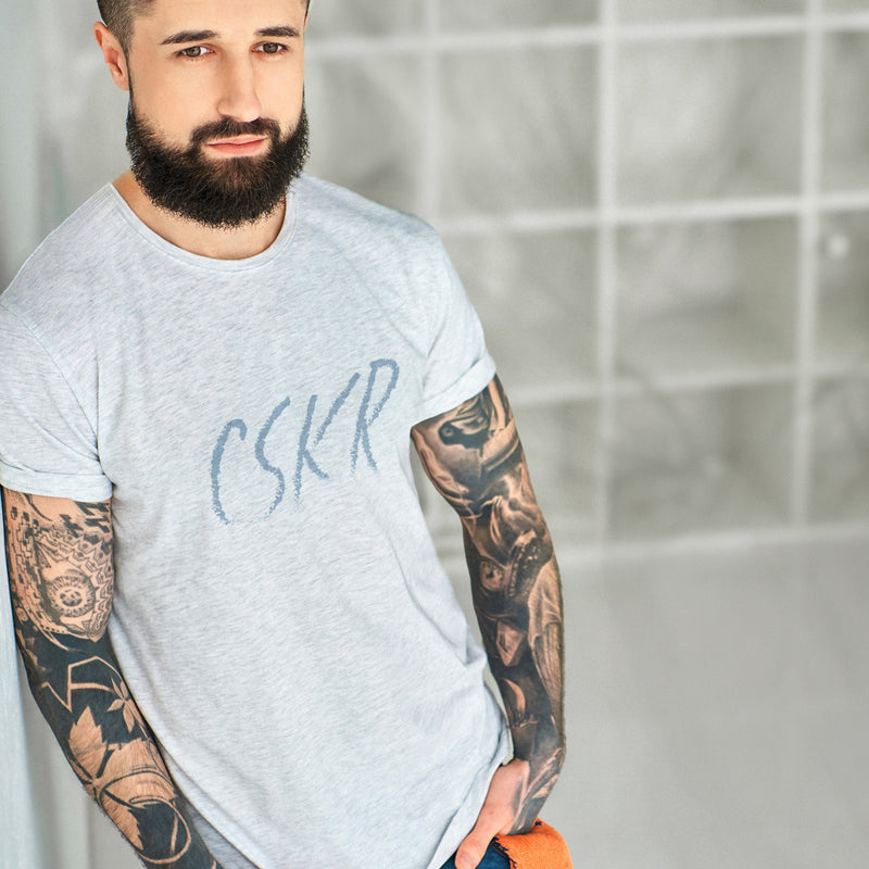 PRODUCT IMAGE: CSKR T-shirt | Dirty Tees for Horny Hungry Gay Guys | Model wears Light Gray Heather shirt with a typographic design