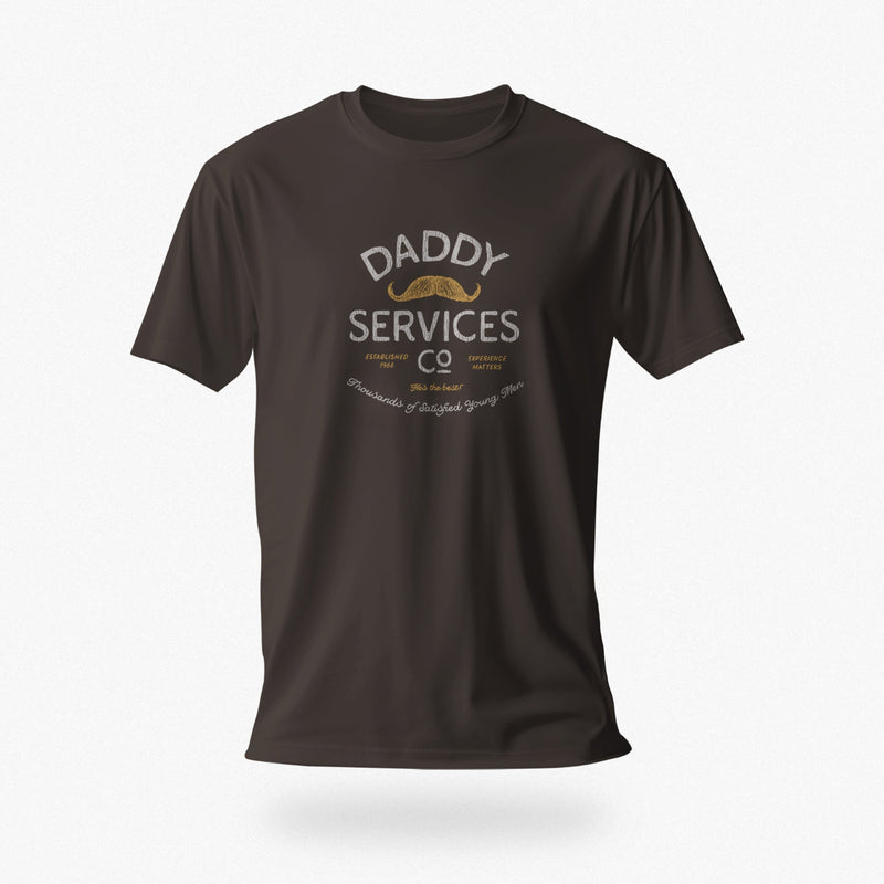 A dark brown short-sleeve t-shirt with a vintage-style graphic on the chest reading 'DADDY SERVICES CO' in white and gold, featuring a gold mustache illustration, shown against a light gray background.