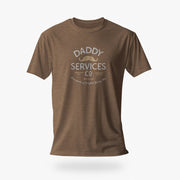A brown short-sleeve crewneck t-shirt with a vintage-style graphic on the chest reading 'DADDY SERVICES CO' with a small mustache illustration, shown against a light gray background.