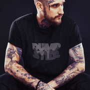 PRODUCT IMAGE: Dumpster T-shirt | Raunchy Tees for Horny Gay Guys Who Take Loads | Model wears Black shirt with a typographic design featuring white dripping liquid referring to a man's cum