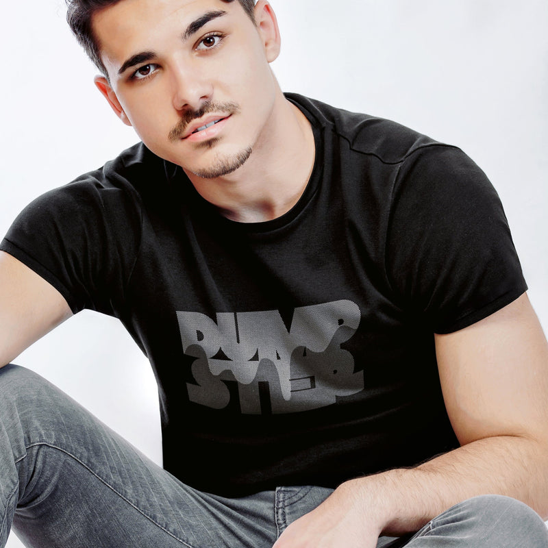 PRODUCT IMAGE: Dumpster T-shirt | Raunchy Tees for Horny Gay Guys Who Take Loads | Model wears Black shirt with a typographic design featuring white dripping liquid referring to a man's cum