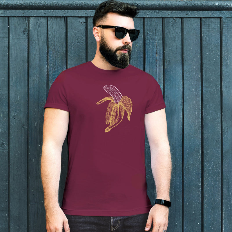PRODUCT IMAGE: Fresh Fruit T-Shirt | Raunchy Tee for Horny Gay Men & Size Queens | Model wears Maroon shirt with a woodcut-style graphic of a colorful banana