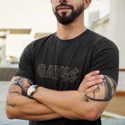 Model wears dark gray GAY4$ shirt with bold, bling-inspired typography — a cheeky, provocative tee for queer men and hustlers alike.