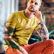 Model wears light yelllow "General Admission" t-shirt | Homo erotic graphic of nude male laying on his stomach, looking up at camera; his back is covered by the letter forms that spell the name of the shirt design | Raunchy Gay Tee for Submissive Males