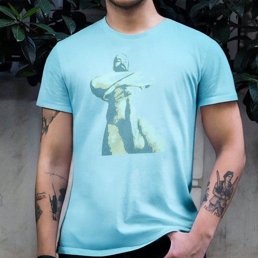 Cropped at the chin, a male model's torso is shown, wearing on Ocean t-shirt with a pop art-styled graphic of bearded daddy — arms crossed, looking down at you with his endowment somewhat abstracted by the graphic treatment