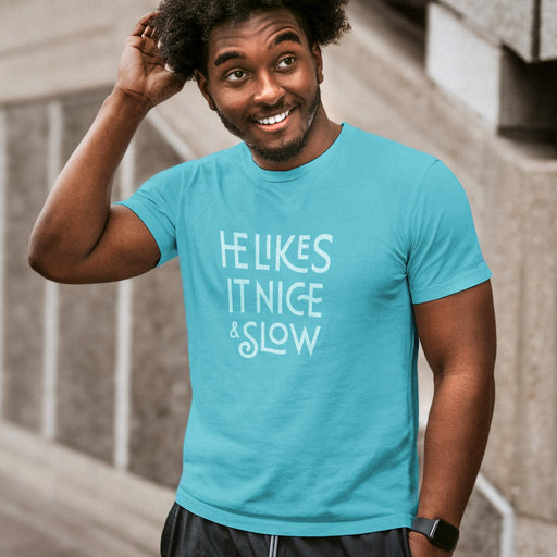 PRODUCT IMAGE: He Likes It Nice & Slow T-shirt | Funny Gay Tee for the guys who take their time and enjoy the ride | Model wears Turquoise shirt with a design borne out of retro-inspired typography