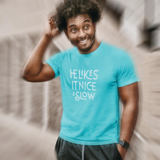 PRODUCT IMAGE: He Likes It Nice & Slow T-shirt | Funny Gay Tee for the guys who take their time and enjoy the ride | Model wears Turquoise shirt with a design borne out of retro-inspired typography