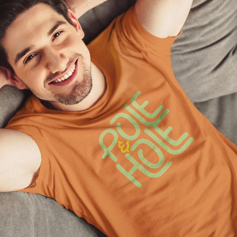 PRODUCT IMAGE: Pole & Hole | SFW, Raunchy Tee for Horny Gay Guys | Model wears Orange tee with the shop's typographic trademark 