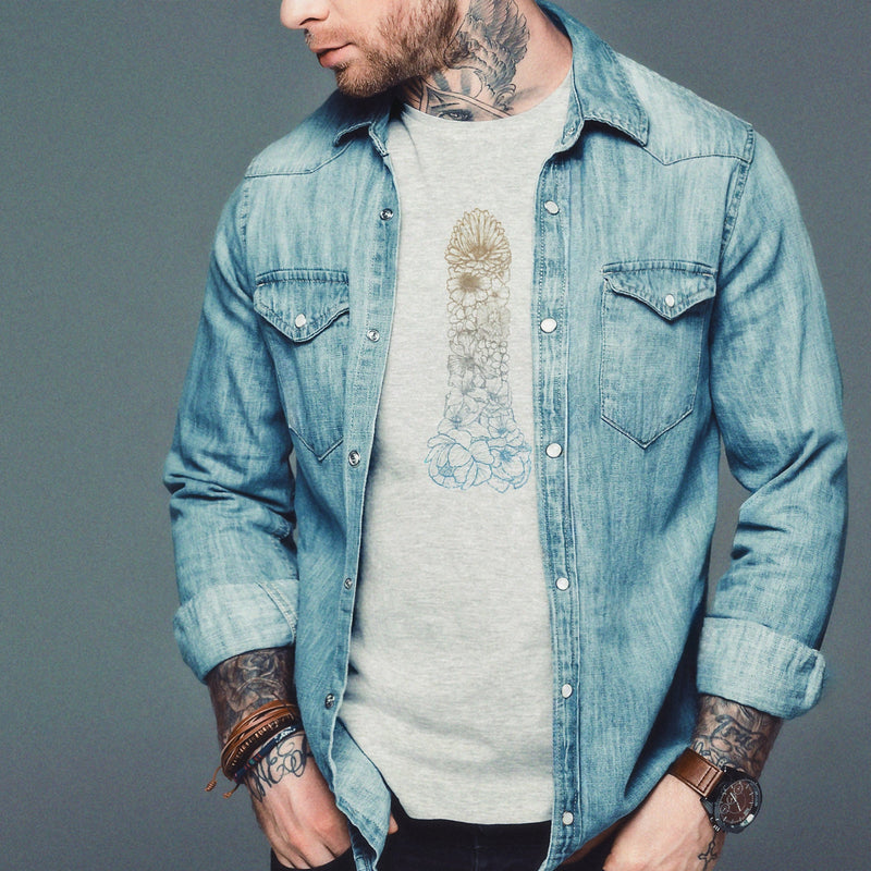 Man wearing a denim shirt over a light gray heather t-shirt against a gray background. The "Pretty Penis" tattoo-style graphic — flowers forming a cock — is printed on the front. Tasteful but NSFW Homo Erotic T-shirt for Horny Gay Men 
