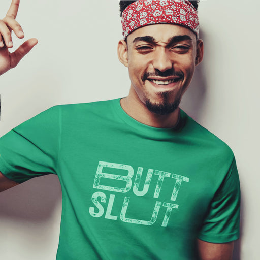 PRODUCT IMAGE: 'Raw Butt Slut' T-shirt | Raunchy Tees for Horny Gay Guys | Model wears Kelly Green shirt with white distressed typography printed on chest