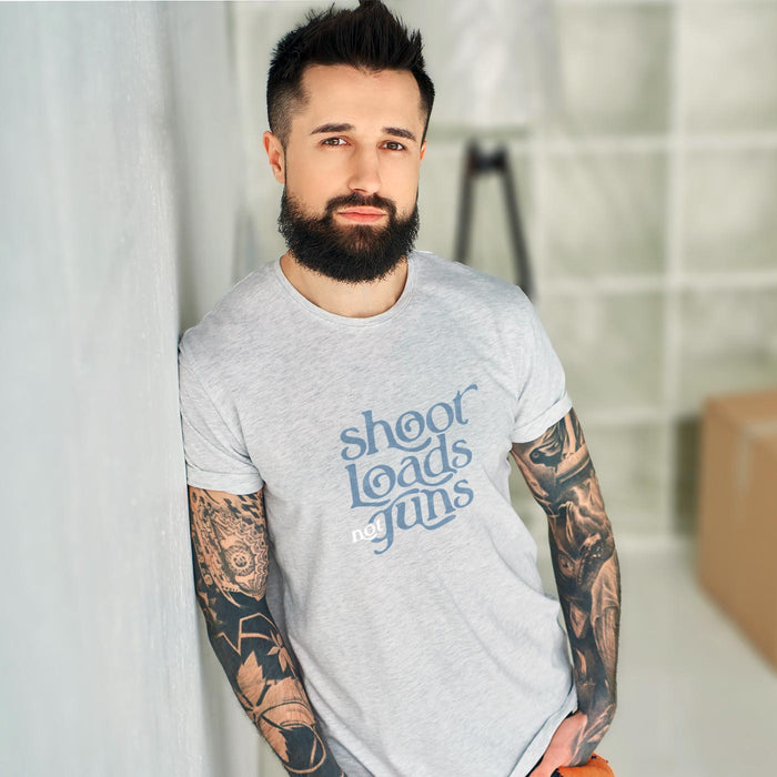 PRODUCT IMAGE: Shoot Loads Not Guns | Conscious and Raunchy T-shirt for Guys into Cum | Model wears Light gray Heather tee with typographic design