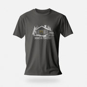 Men’s graphic t-shirt showing a snowy log cabin and plow truck, featuring the phrase “Snowed In, Plowed Out,” a subtle innuendo design for gay men; product photo of asphalt tee.