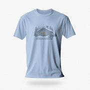 Men’s graphic t-shirt showing a snowy log cabin and plow truck, featuring the phrase “Snowed In, Plowed Out,” a subtle innuendo design for gay men; product photo of Light Blue tee.
