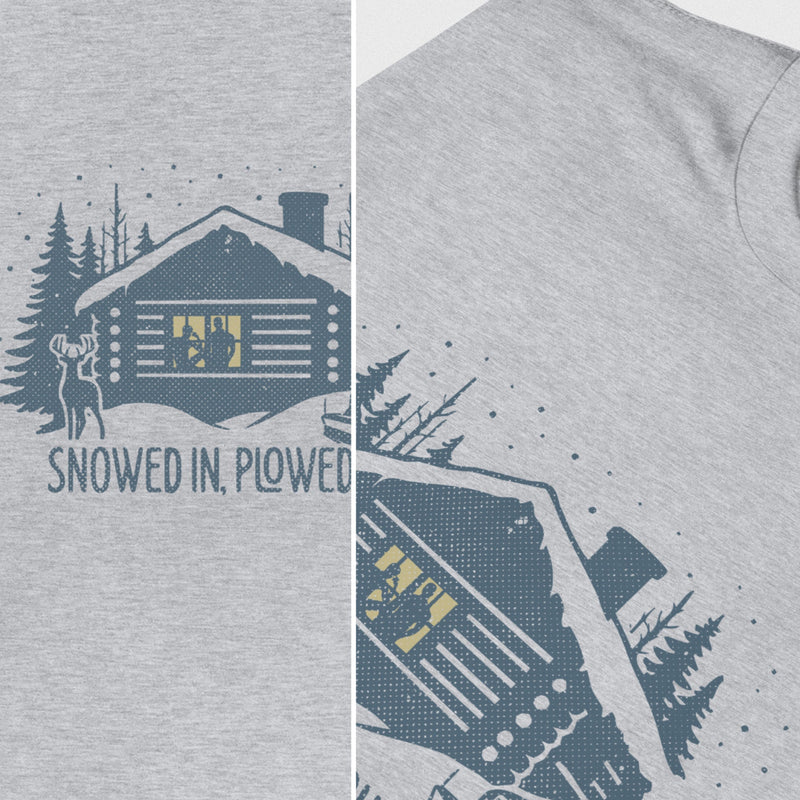 Men’s graphic t-shirt showing a snowy log cabin and plow truck, featuring the phrase “Snowed In, Plowed Out,” a subtle innuendo design for gay men. A diptych provides a close up view of the light gray heather shirt.