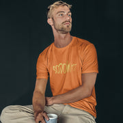PRODUCT IMAGE: Sodomite T-Shirt | Raunchy Tee for Horny Gay Men & Queer Rebels | Model wears Orange  shirt with typographic design