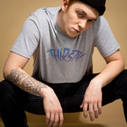 PRODUCT IMAGE: Thirsty T-shirt | Raunchy Tees for Horny Gay Guys Who Thirst for It | Model wears Light Gray heather shirt with a typographic design