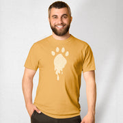 Trail | Raunchy T-shirt for Horny Gay Bears on the Hunt | Man wearing a mustard yellow t-shirt with a white paw print design on a plain background 