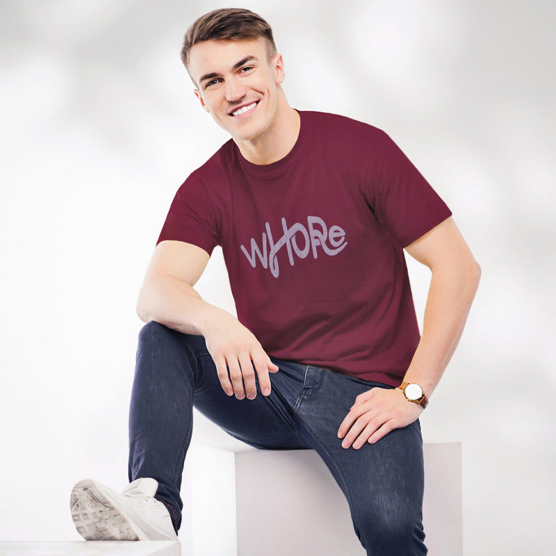 PRODUCT IMAGE: Whore | Offensive NSFW T-shirt for shamelessly Horny Gay Guys | model wears maroon shirt with light colored, distressed typographic design on chest